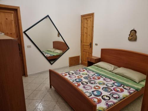 a bedroom with a bed with a mirror on the wall at Abbronzatissima Capo d'Orlando in Capo dʼOrlando