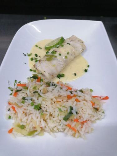a plate of food with rice and chicken and vegetables at Moselromantik Hotel Am Panoramabogen in Cochem