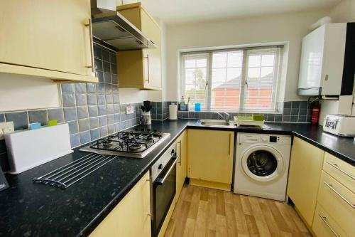 a kitchen with a stove and a washing machine at "Fishermans House" By Greenstay Serviced Accommodation - Large 4 Bed House With Parking - The Perfect Choice For Contractors, Families & Mixed Groups in Grimsby