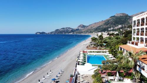 a view of a beach with chairs and the ocean at Park Hotel Silemi in Letojanni