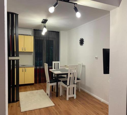 cocina y comedor con mesa y sillas en EUNICE apartament, en Oradea