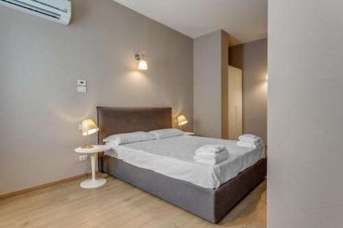 a bedroom with a bed and a table with a lamp at JOIVY Treviso Vittoria in Treviso