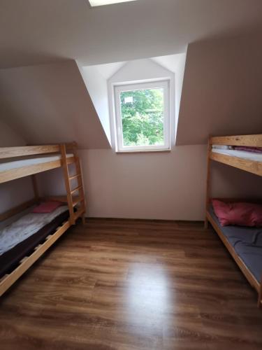 a room with two bunk beds and a window at Schronisko młodzieżowe w Jabłonkach in Jabłonki