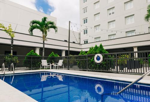 a pool in front of a building with a volley ball at Holiday Inn San Salvador, an IHG Hotel in San Salvador