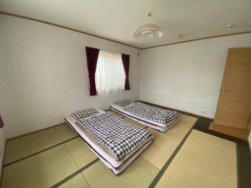 two beds in a small room with a window at 澄の宿 琵琶湖畔松の浦水泳场 jr志賀车站 滑雪场登山巴士站全部徒步0分钟 免费停车位3台 in Otsu