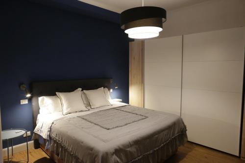 a bedroom with a large bed with a blue wall at CasaMica L'Aquila in LʼAquila