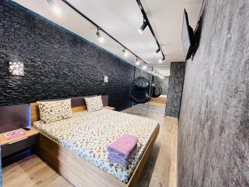 1 dormitorio con cama y pared negra en LUX с джакузи RIVER PARK (дуэт), en Dnipro