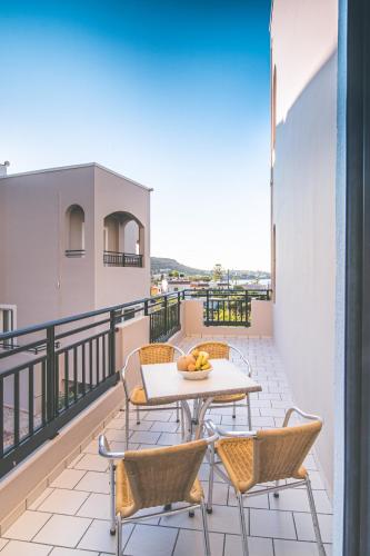 a patio with a table and chairs on a balcony at Rainbow Apartments in Stalida