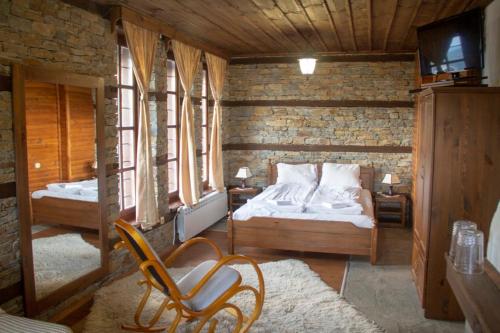 a bedroom with a bed and a chair in a room at Leshtenski Rai Guest House in Leshten