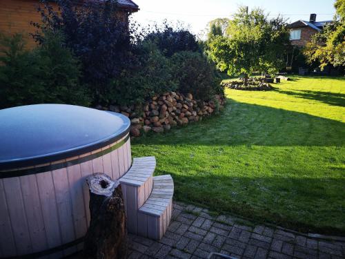 a bench sitting next to a barrel in a yard at Viesu nams AMRAI in Ventspils