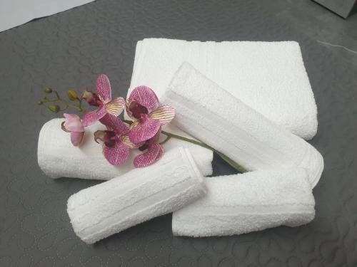 two white towels with flowers on a table at La Punta in San Giovanni la Punta