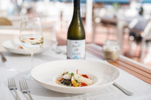 a plate of food and a bottle of wine on a table at Golfo del Sole Hotel & Holiday Resort in Follonica