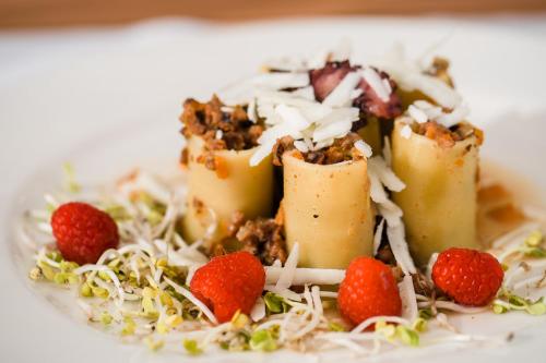 a dessert with fruit and strawberries on a white plate at Golfo del Sole Hotel & Holiday Resort in Follonica