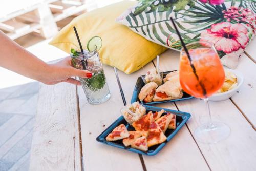 a table with two plates of food and a drink at Golfo del Sole Hotel & Holiday Resort in Follonica