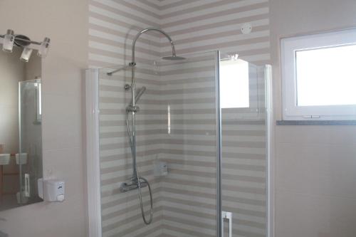 y baño con ducha y puerta de cristal. en Girassol Alojamento Local, en Montemor-o-Novo