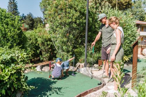 a woman and a man playing a game of miniature golf at Golfo del Sole Hotel & Holiday Resort in Follonica