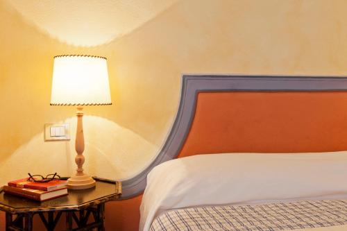 a bedroom with a bed with a lamp and books at Marchesi Incisa Winery Lodge in Rocchetta Tanaro