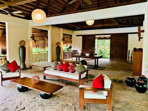 a living room with couches and tables in a room at Amun Ini Beach Resort & Spa in Anda