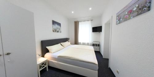 ein kleines Schlafzimmer mit einem Bett und einem Fenster in der Unterkunft Pension Ikar in Schwerin