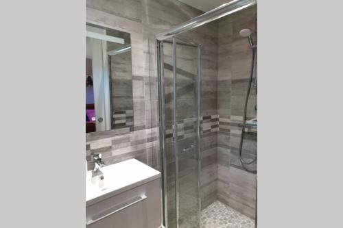 a bathroom with a glass shower and a sink at Agréable logement pour 4 pers à deux pas de Verdun in Haudainville