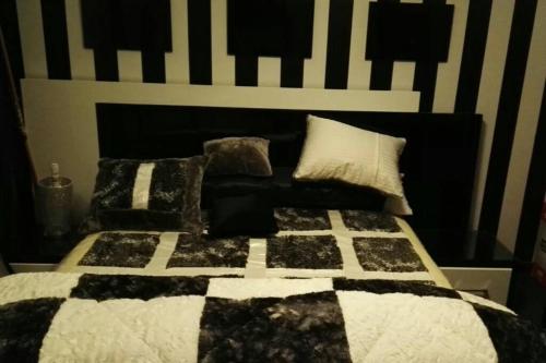 a bed with a black and white comforter and pillows at Luxurious & Large Modern Penthouse in Cairo