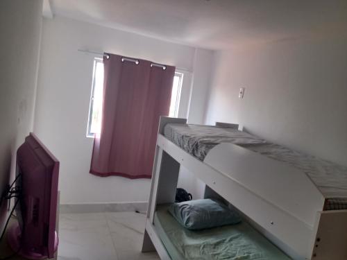 a bedroom with a bunk bed and a television at Vila Suítes Coliving in Vila Velha