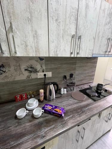 a kitchen with a counter top with white cabinets at MODERN AND COMFORTABLE APARTMENT Self Check In in Yerevan