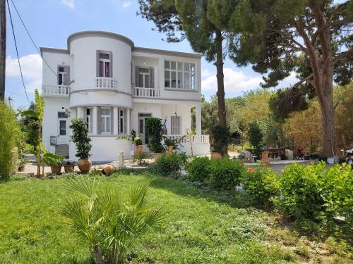 a white house with trees and a yard at Tower traditional pool villa in Kremasti