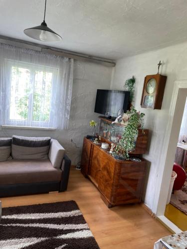a living room with a couch and a flat screen tv at Domek U Babci in Myscowa