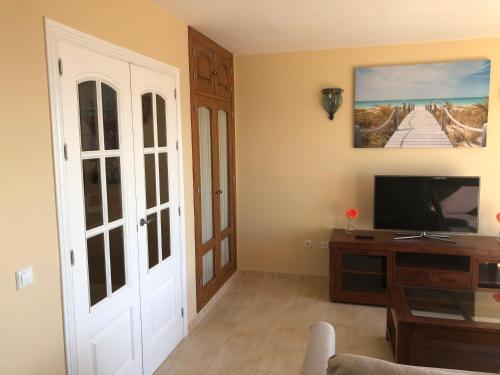 Una televisión o centro de entretenimiento en Fantástico apartamento frontal en el mar Fuengirola