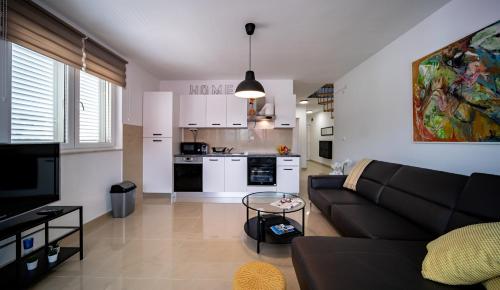 a living room with a couch and a kitchen at Apartman Dora in Rab