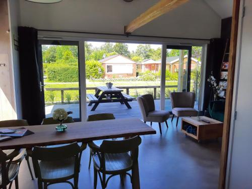 a dining room with a table and chairs and a patio at Vakantievilla 10 km van strand honden welkom omheinde tuin sauna buitenbad in Dirkshorn