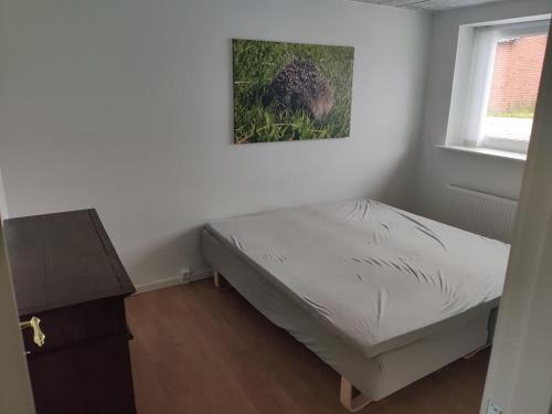 a small bedroom with a bed and a window at Ferielejlighed ved Vilsted Sø in Løgstør