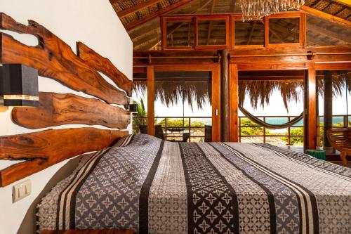 ein Schlafzimmer mit einem Bett in einem Zimmer mit Fenstern in der Unterkunft ALAS Y ARENA in Vichayito