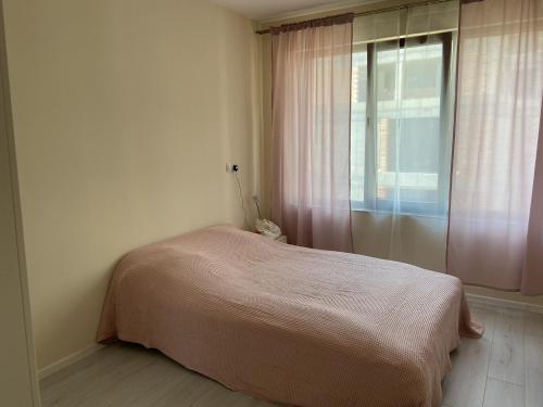 a bedroom with a bed and a window at Apartments Pomorie Tundzha 9 in Pomorie