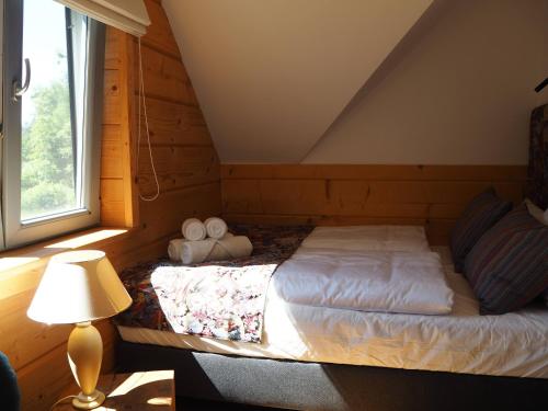 um quarto com uma cama com um candeeiro e uma janela em Cisza i Wiatr II Nielisz Roztocze em Nielisz