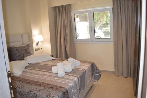 a bedroom with a bed with towels on it at Glyfada Beach Hotel in Glyfada
