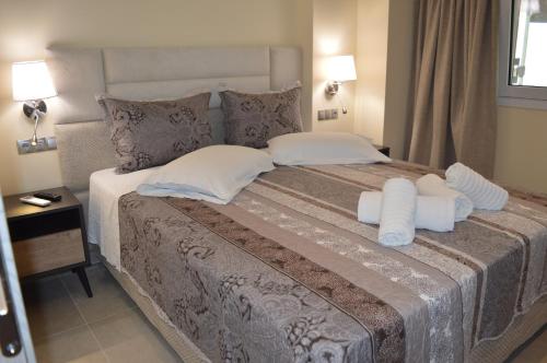 a bedroom with a large bed with towels on it at Glyfada Beach Hotel in Glyfada