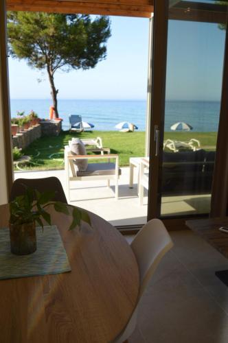 a dining room with a table and a view of the ocean at Glyfada Beach Hotel in Glyfada