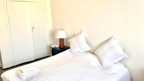een bed met witte lakens en kussens in een slaapkamer bij Popular, Central & Cheap in Rabat