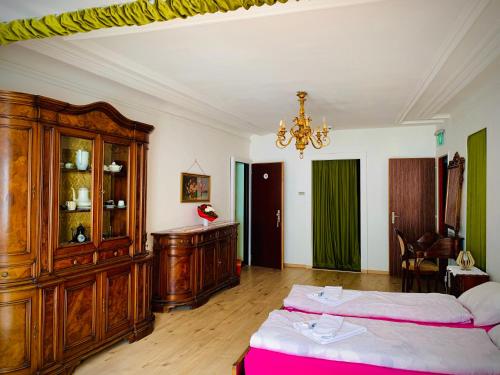 a bedroom with two beds and a chandelier at Weisses Rössli in Leukerbad