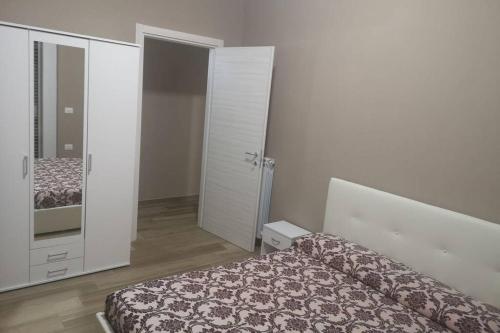a bedroom with a bed and a large mirror at Parco Nazionale Cilento e Vallo di Diano Apartment in Casalbuono