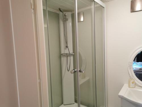 um chuveiro com uma porta de vidro na casa de banho em Molle Annexet -Lantlig Gastsvit i Rolfstorp em Rolfstorp