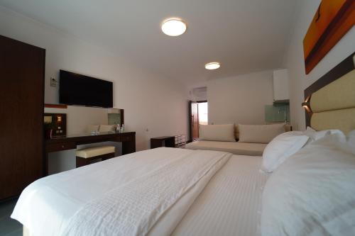 a bedroom with a large white bed and a couch at Valentinos House in Parga