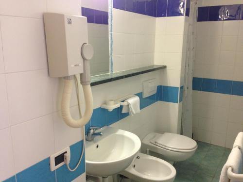 bagno con lavandino, servizi igienici e telefono di Hotel Gemma a Ischia