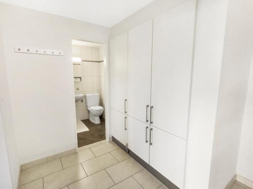 ein Badezimmer mit weißen Schränken und einem WC in der Unterkunft ARISER - Mountain View Business Apartment in Zug