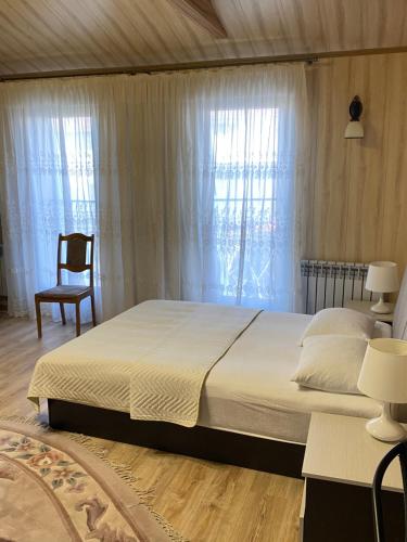 a bedroom with a large bed and a chair at Комнаты с удобствами у моря in Gelendzhik