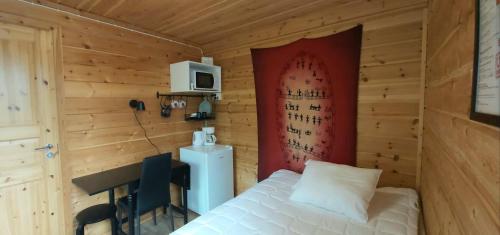 a bedroom with a bed and a desk and a microwave at Hillside Rooms in Ivalo