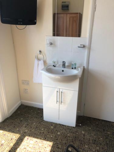 a bathroom with a sink and a mirror at Nook and Harbour Holiday Apartments & rooms in Weston-super-Mare