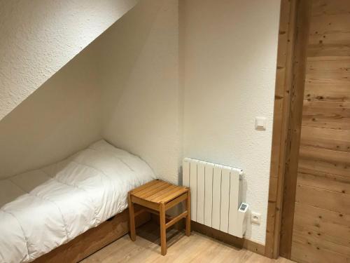 ein kleines Schlafzimmer mit einem Bett und einem Holztisch in der Unterkunft Studio Montgenèvre, 1 pièce, 6 personnes - FR-1-445-150 in Montgenèvre